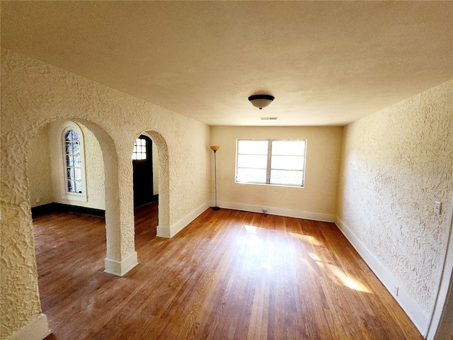 spare room with hardwood / wood-style floors and a textured ceiling