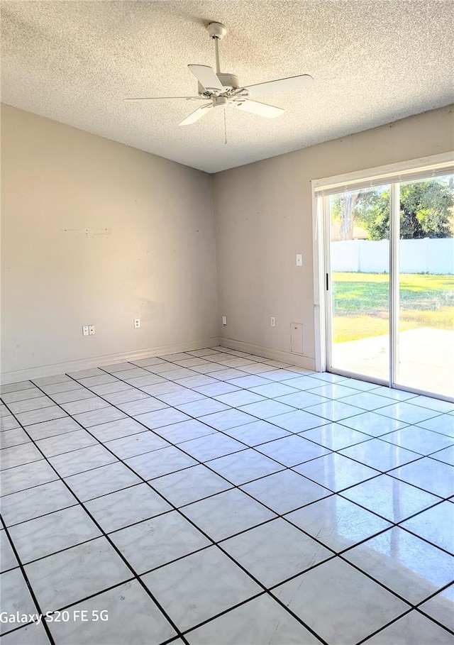 tiled empty room with ceiling fan and a textured ceiling