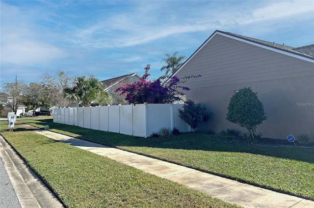 view of side of home with a yard