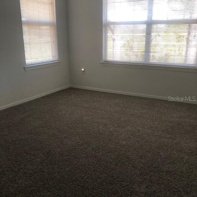 spare room featuring dark carpet