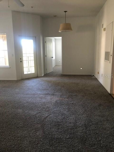 carpeted empty room featuring ceiling fan