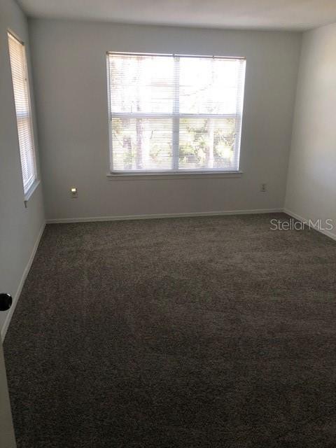 unfurnished room with dark colored carpet