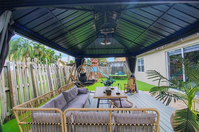 wooden terrace featuring a gazebo, an outdoor hangout area, a playground, and a lawn