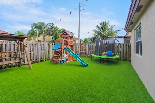 view of jungle gym featuring a yard and a trampoline