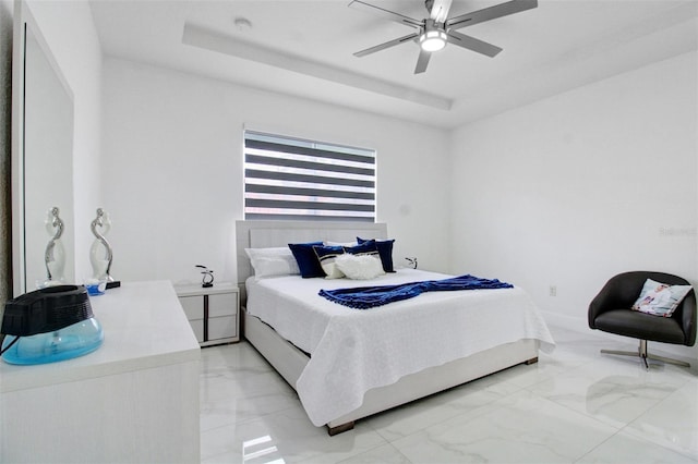 bedroom featuring ceiling fan and a raised ceiling