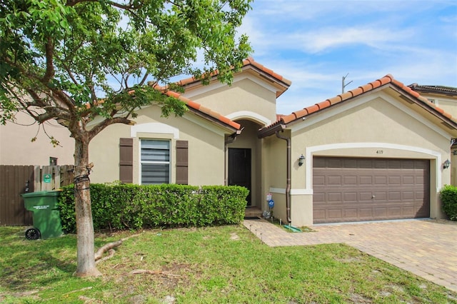 mediterranean / spanish home featuring a garage and a front lawn