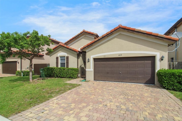 mediterranean / spanish-style home featuring a garage and a front yard