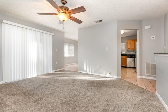 unfurnished room featuring light carpet, a textured ceiling, and ceiling fan