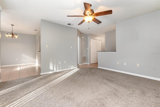 spare room featuring ceiling fan with notable chandelier, a textured ceiling, and light carpet