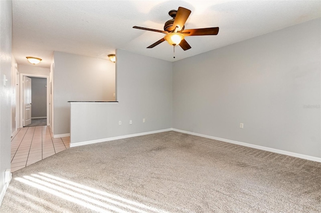 spare room with a textured ceiling, ceiling fan, and light carpet