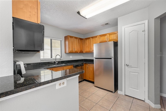 kitchen with kitchen peninsula, appliances with stainless steel finishes, light tile patterned flooring, and sink