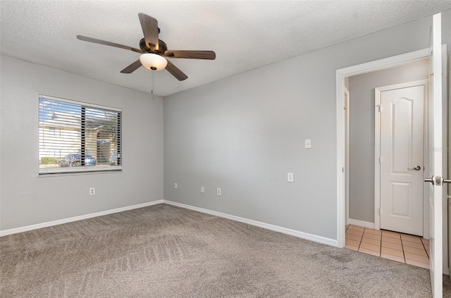 carpeted spare room with a textured ceiling and ceiling fan