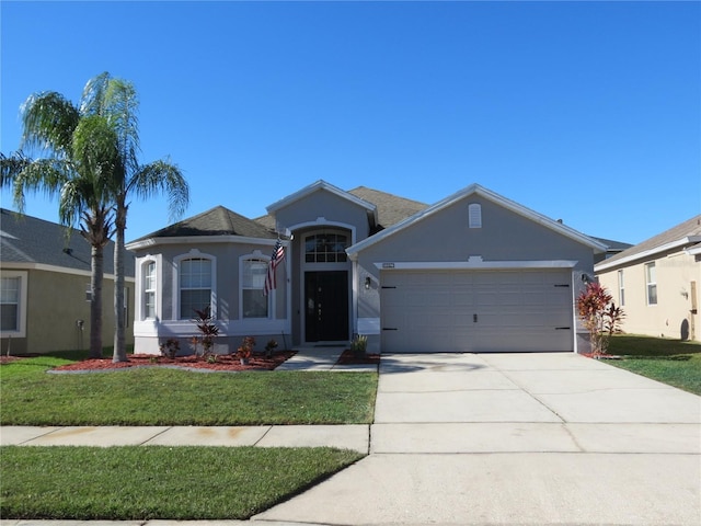 ranch-style house with a garage and a front lawn