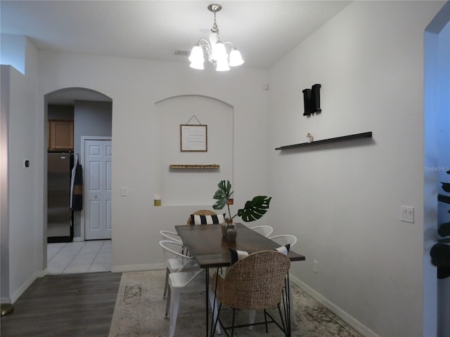 dining area featuring hardwood / wood-style floors and an inviting chandelier