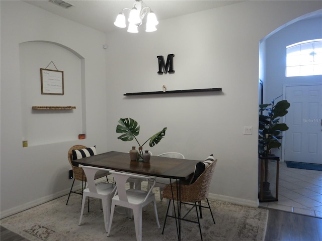 dining room featuring hardwood / wood-style flooring and an inviting chandelier