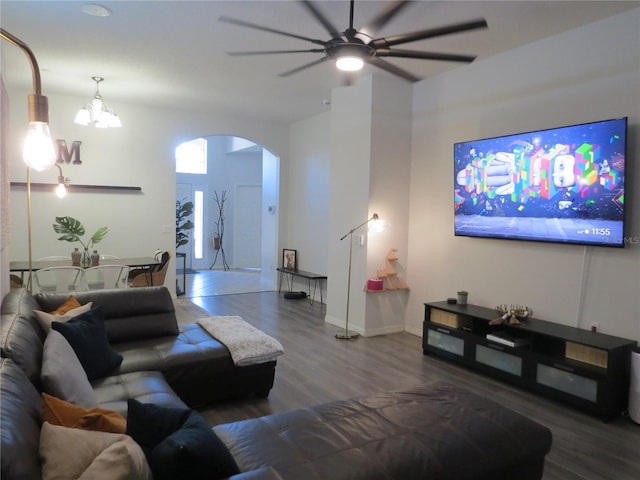 living room with ceiling fan with notable chandelier and wood-type flooring