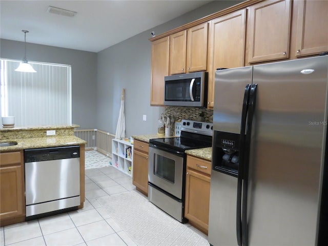 kitchen with hanging light fixtures, decorative backsplash, light tile patterned floors, light stone countertops, and appliances with stainless steel finishes