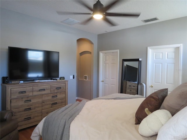 bedroom featuring ceiling fan, wood-type flooring, and a textured ceiling