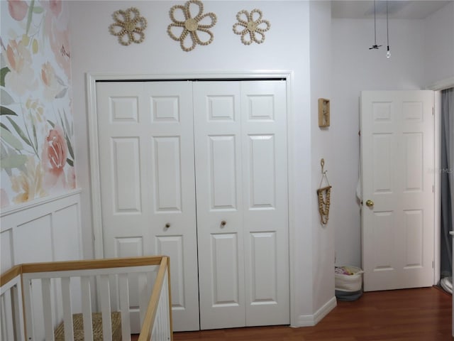 unfurnished bedroom with dark hardwood / wood-style flooring, a closet, and a nursery area