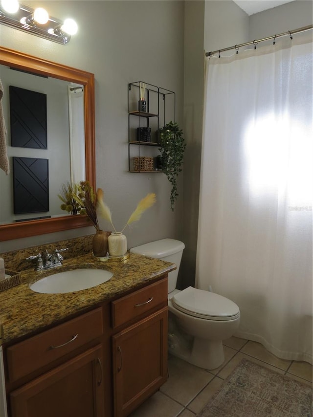 bathroom featuring toilet, vanity, tile patterned floors, and curtained shower