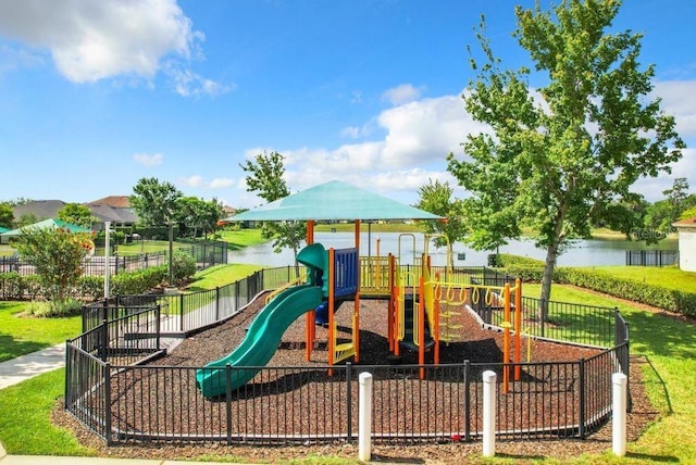 view of jungle gym featuring a water view and a lawn