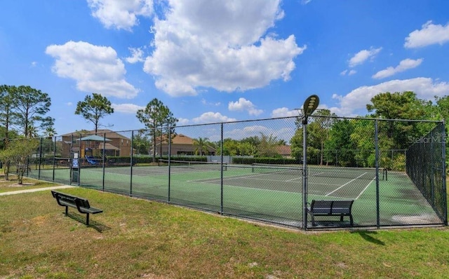 view of tennis court featuring a yard