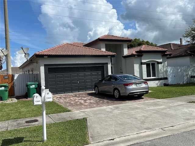 mediterranean / spanish home with a front yard and a garage