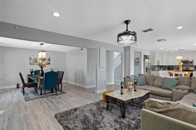 living room with a chandelier and light hardwood / wood-style floors