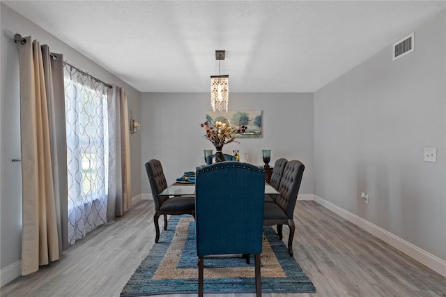 dining room with hardwood / wood-style flooring and an inviting chandelier