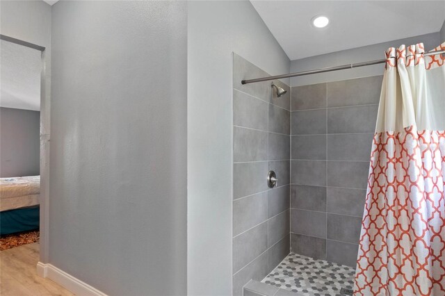 bathroom with hardwood / wood-style flooring and a shower with curtain