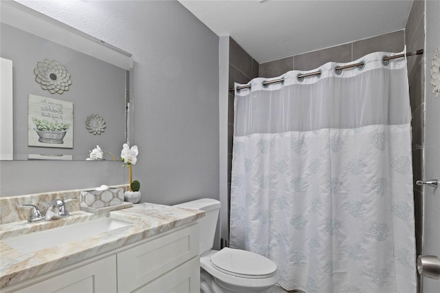 bathroom featuring a shower with curtain, vanity, and toilet