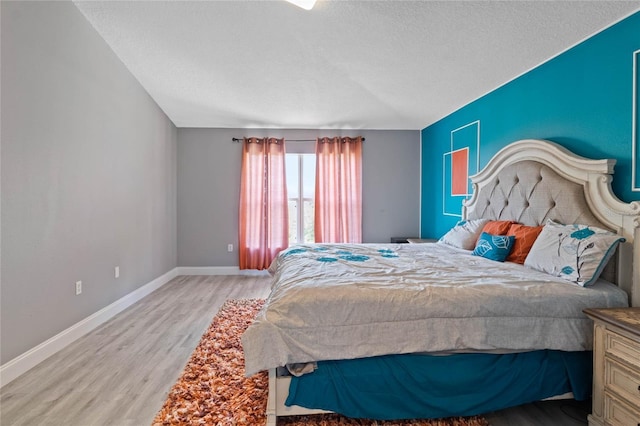 bedroom featuring light wood-type flooring and a textured ceiling