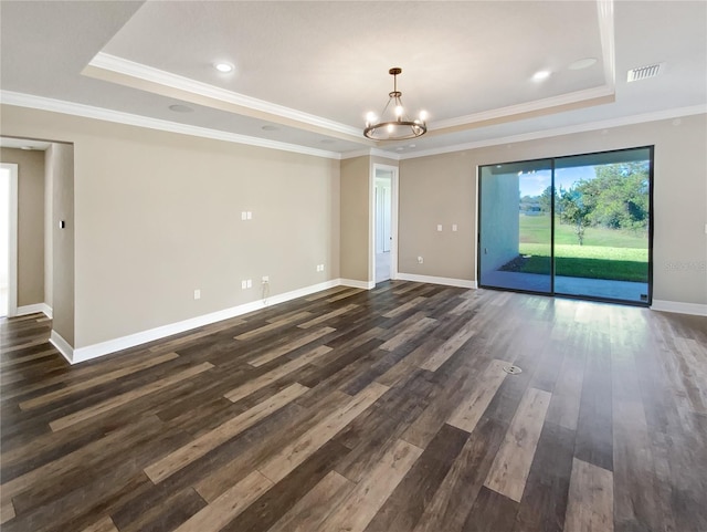 spare room featuring a tray ceiling, dark hardwood / wood-style floors, and ornamental molding