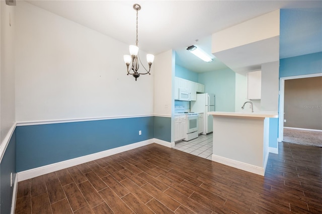 kitchen with kitchen peninsula, white cabinetry, white appliances, and light wood-type flooring