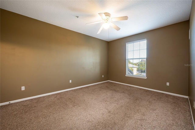 spare room featuring a textured ceiling, carpet floors, and ceiling fan