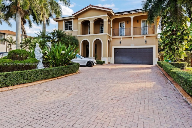 mediterranean / spanish-style home featuring a balcony and a garage