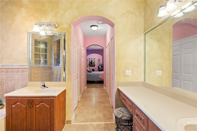 bathroom with tile walls, tile patterned flooring, and vanity