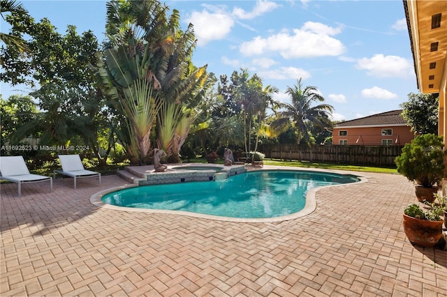 view of pool featuring a patio and an in ground hot tub