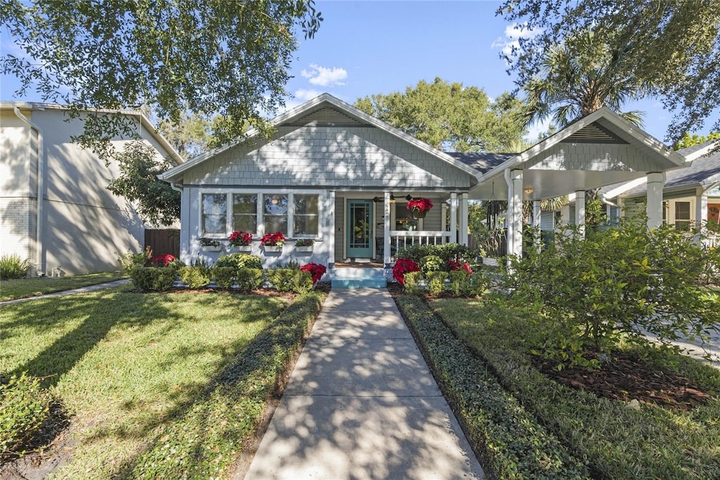 bungalow-style house with covered porch and a front lawn