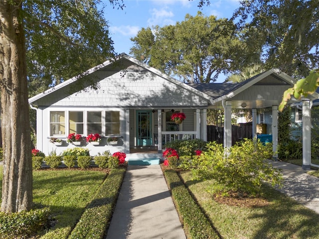 view of front of home with a front lawn, a porch, and a carport