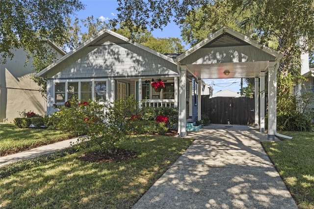 bungalow-style house with a carport, a porch, and a front lawn