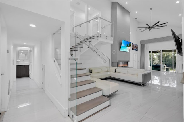 stairway with ceiling fan, french doors, and a towering ceiling