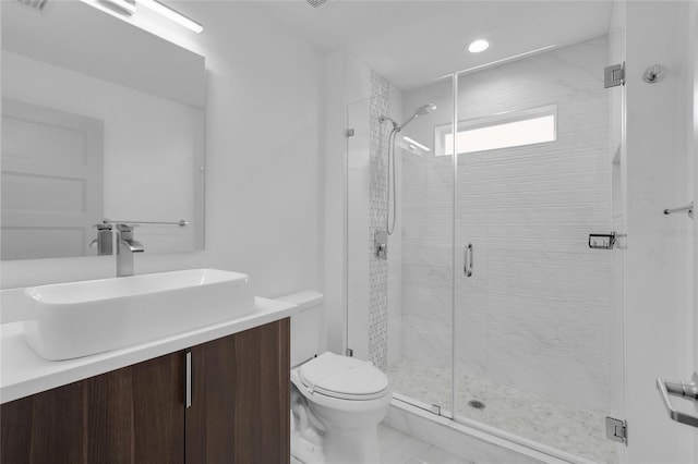 bathroom with walk in shower, vanity, and toilet