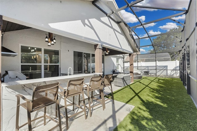 back of house featuring glass enclosure, a yard, a bar, and a patio