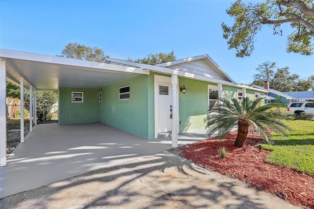 view of front of property featuring a front lawn and a carport