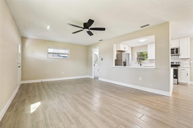 unfurnished living room featuring light hardwood / wood-style flooring and ceiling fan