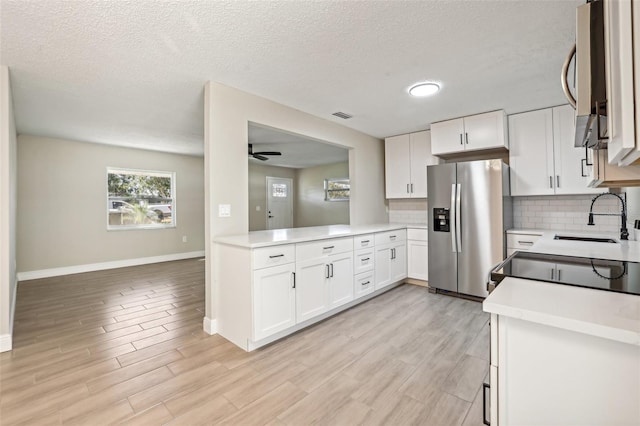 kitchen featuring white cabinets, appliances with stainless steel finishes, light wood-type flooring, and sink