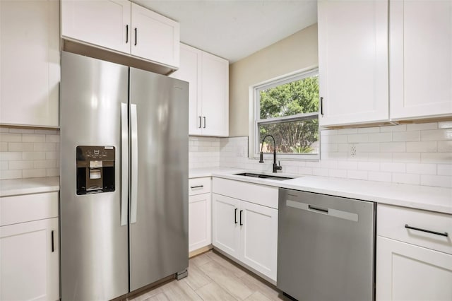 kitchen with white cabinets, appliances with stainless steel finishes, backsplash, and sink