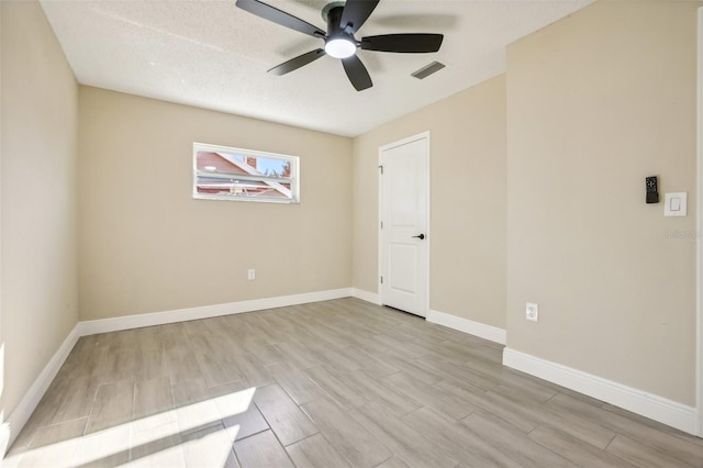 unfurnished room featuring ceiling fan, light hardwood / wood-style flooring, and a textured ceiling