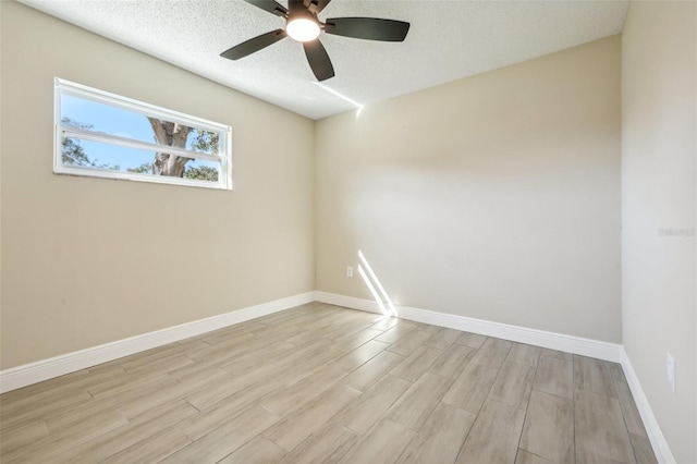 empty room featuring a textured ceiling, light hardwood / wood-style flooring, and ceiling fan